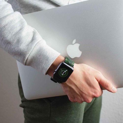 Green-guerilla-suede-band-with-a-silver-macbook-in-the-other-hand