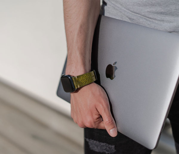 AW-bullet-proof-green-leather-band-handling-a-silver-macbook