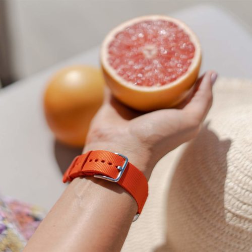 Apple-watch-orange-tide-band-recycled-ocean-plastic-woman-handling-a-grapefruit-on-back-side